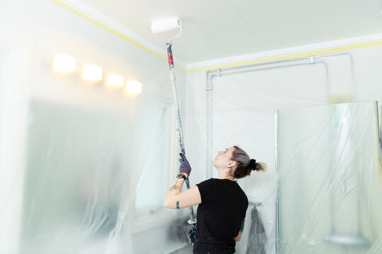 Woman painting ceiling, Sweden