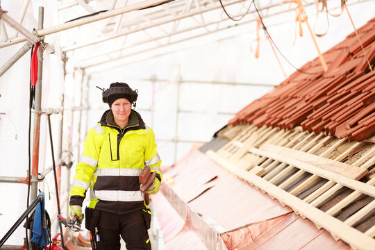 Woman working on roof, Sweden