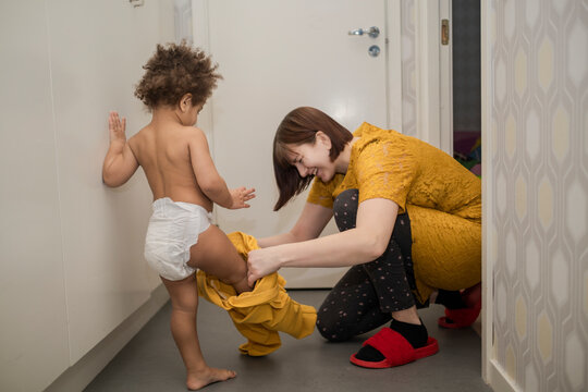 Mother helping daughter to get dressed, Sweden