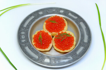 toast with red caviar on a plate delicious nutritious snack on white background