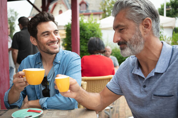 two men cheers drink coffee