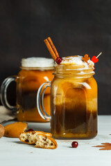 Two mugs with Pumpkin latte and cookies close-up on a black background, vertically with space