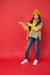 kid in knitwear accessory apparel pointing finger, copy space. enjoy weather and softness. cozy sweater. autumn season fashion. teenage girl in soft garment. warm clothing trends. childhood happiness