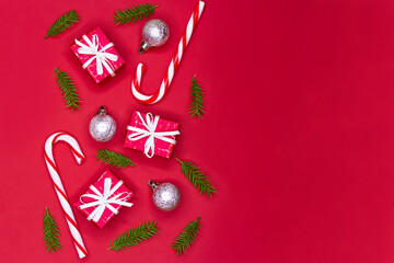 Christmas tree composition border design. Christmas red decorations, fir tree branches on red background with copy space.