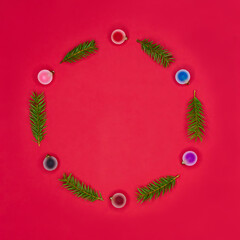 Holiday concept, New Year, greeting card. Creative composition of Christmas tree balls and branches on a red background. Round decorative frame. Top view.