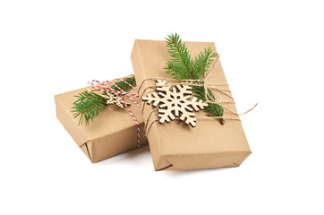 Two christmas gift boxes decorated with fir tree branch and wooden snowflakes isolated on white background