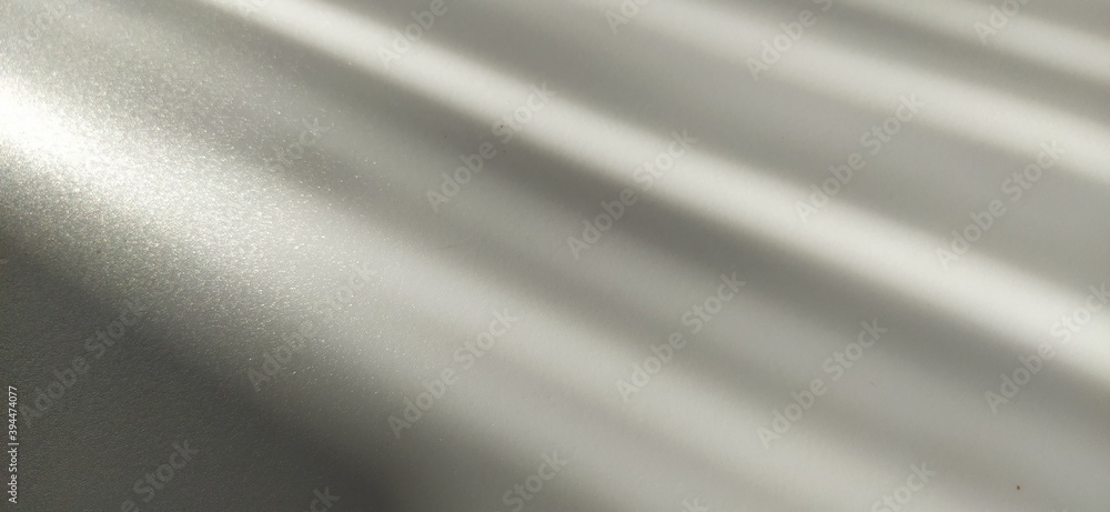 Poster gray striped background with oblique light effect. play of light and shadow. light rays. gray and si