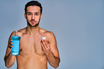 Guy with smile with black hair with a beard rinses his mouth with a remedy. Dental concept