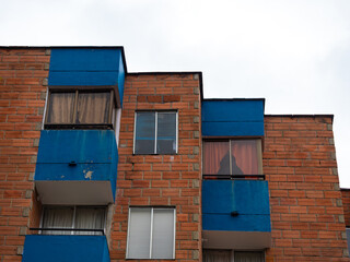 View of the Windows of a Brick Building with Worn blue Paint