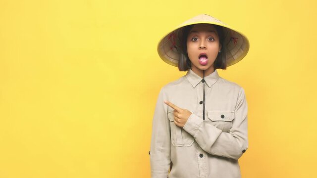 Young latin woman with vietnamite hat  pointing to the side