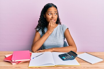 Young african american girl accountant working at the office looking stressed and nervous with...