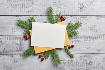 Christmas greeting card mockup with fir tree branches and holly beries