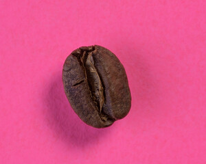 Naklejka premium Closeup shot of a coffee bean on pink