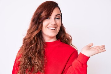 Young beautiful woman wearing casual clothes smiling cheerful presenting and pointing with palm of hand looking at the camera.
