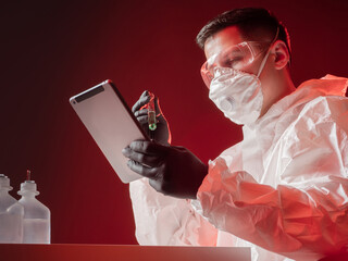 Laboratory analysis. A chemist with a test tube and a tablet computer in his hands. A man in a...