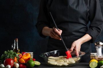 Professional chef cooking baked potato with seafood. Backstage of preparing delicious dinner on dark blur background. Frozen motion. Concept of exotic asian cuisine. Cooking process.