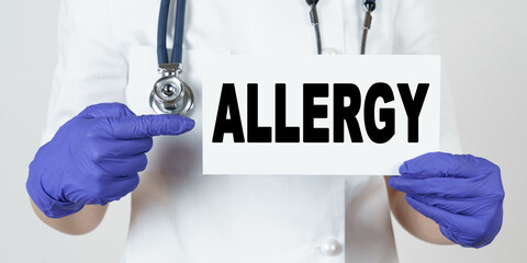 The doctor points his finger at a sign that says - ALLERGY