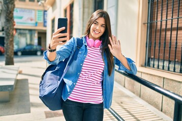Young hispanic student girl smiling happy doing video call using smartphone at the city.