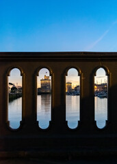 view through balustrade of the old harbor of La Rochelle at blue hour with its famous old towers. 