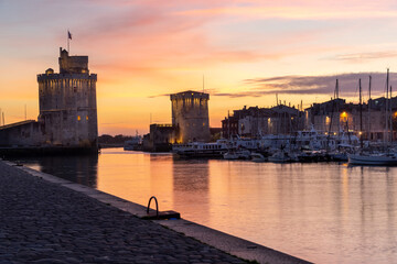 Panoramic view of the old harbor of La Rochelle at sunset with its famous old towers