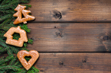 Gingerbread cookies and fir branches on a dark wooden background. Christmas blank for text, congratulations, inscriptions. with place for text. new Year