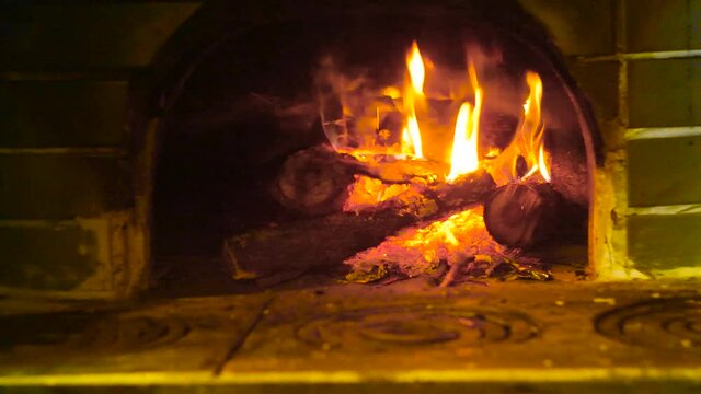 Firewood burning in the oven. Pizza oven. Flame of wood stove fire in the dark.