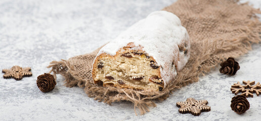 Christstollen, traditonal christmas cake with nuts, raisons, marzipan on a blue background, empty space for text