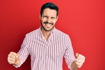 Young hispanic man wearing business shirt very happy and excited doing winner gesture with arms raised, smiling and screaming for success. celebration concept.