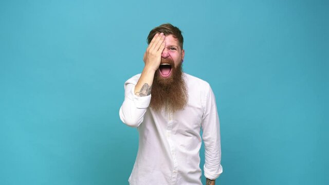 Young adult bearded caucasian man isolated having fun covering half of face with palm