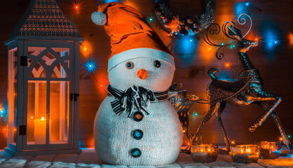 Snowman in a red cap and lights with wooden background. Christmas decoration