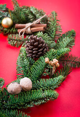 Christmas pine door wreath on red background decorated with cookies with icing in Christmas setting, mock up frame for text in center
