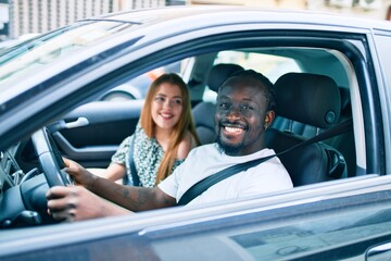 Young interracial couple smiling happy at the car.