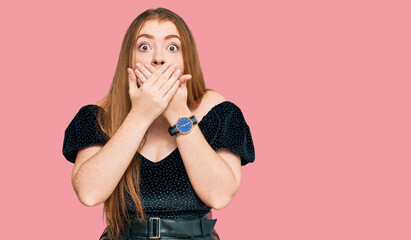 Young beautiful redhead woman wearing elegant clothes shocked covering mouth with hands for...