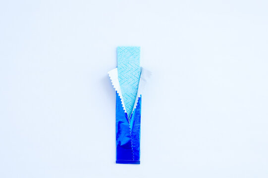  chewing gum unwrapped in a blue package. White background.