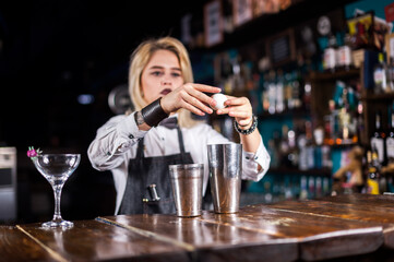 Girl barman concocts a cocktail at the beerhouse