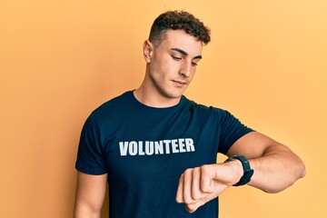 Handsome young man wearing volunteer t shirt cutting throat with hand as knife, threaten aggression with furious violence