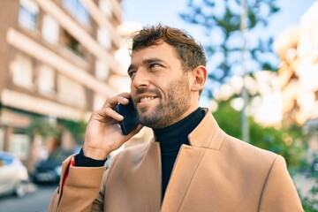 Handsome business man wearing elegant jacket using smartphone smiling happy outdoors