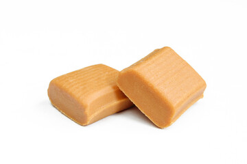 Two unwrapped caramel candies isolated on white background. Sweet delicious snack