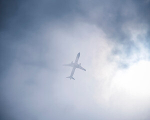 Airplane appearing through the clouds.
