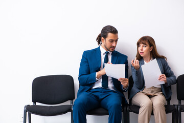 Obraz premium Young businessman and businesswoman waiting for an interview at