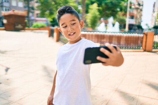 Adorable boy smiling happy making selfie by the smartphone at street of city.