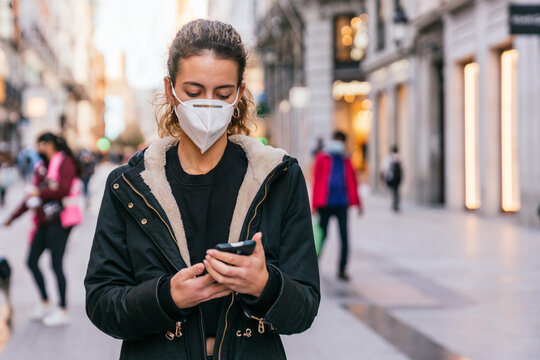 New normal. Teenager using her smartphone.Young girl using her smart phone. New technologies. Using your Smartphone. Mask against covid. Teenager with face mask. Pandemic. Teenager talking.