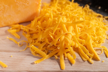 Cheddar Cheese Grated on a Cutting Board