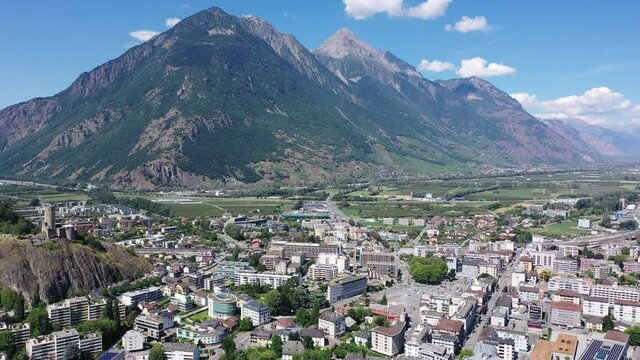 View from drone of houses of commune Martigny and river Drance in mountain valley, Switzerland