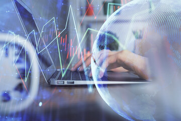 Double exposure of woman hands typing on computer and forex chart hologram drawing. Stock market...