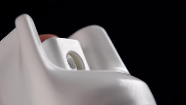 Using a disinfectant spray close up on a black background. Alcohol sanitizer to protect against virus bacteria. Slow motion