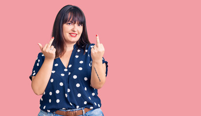 Young plus size woman wearing casual clothes showing middle finger doing fuck you bad expression,...
