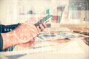 Double exposure of man's hands holding and using a phone and financial graph drawing. Analysis...