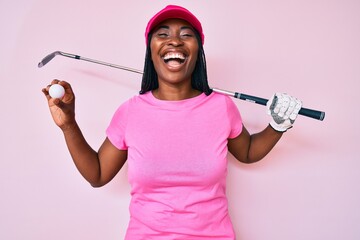 African american golfer woman with braids holding golf ball smiling and laughing hard out loud...