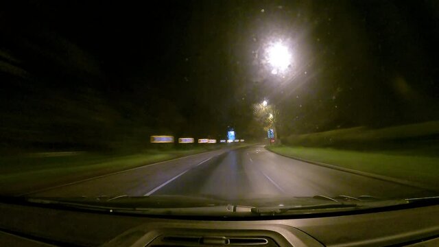 Pov time lapse of car leaving the motorway and driving back through town at night